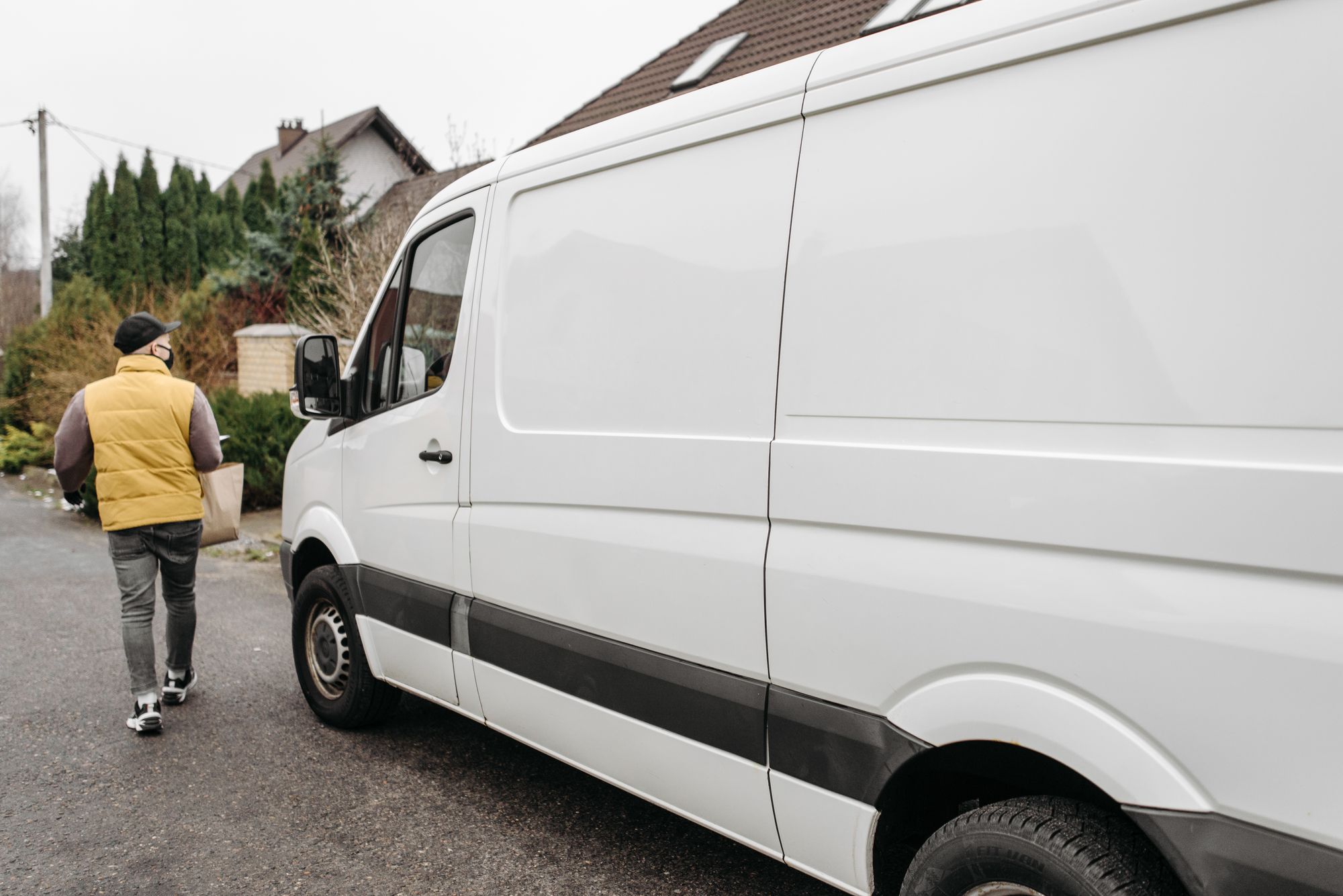 Kurierfahrer lädt Pakete in einen Transporter