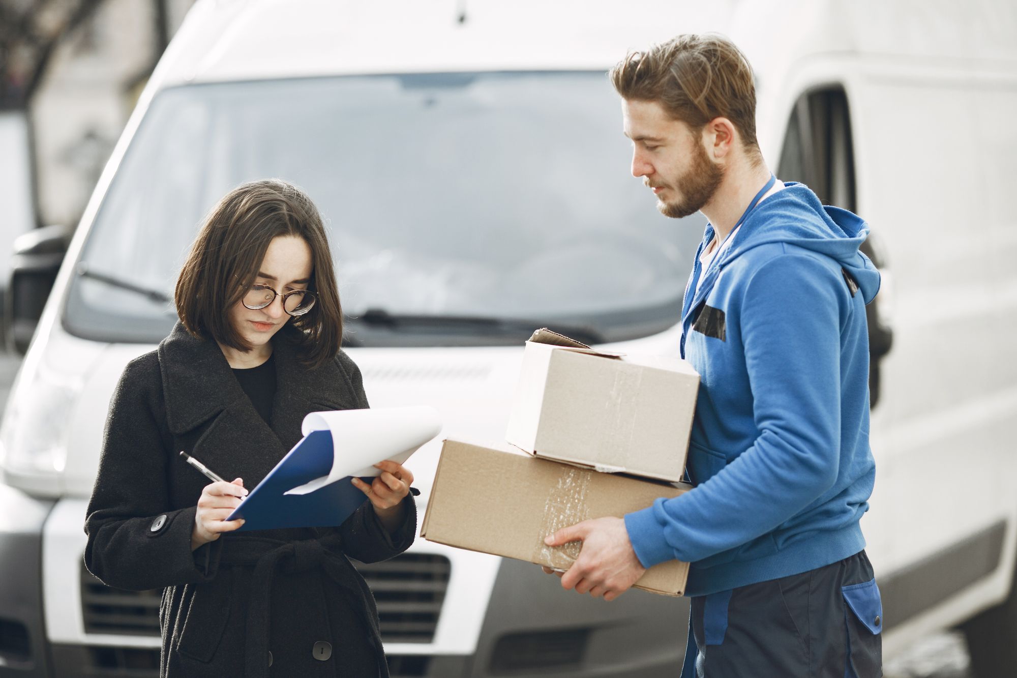 Paketübergabe am Transporter mit digitaler Bestätigung der Zustellung