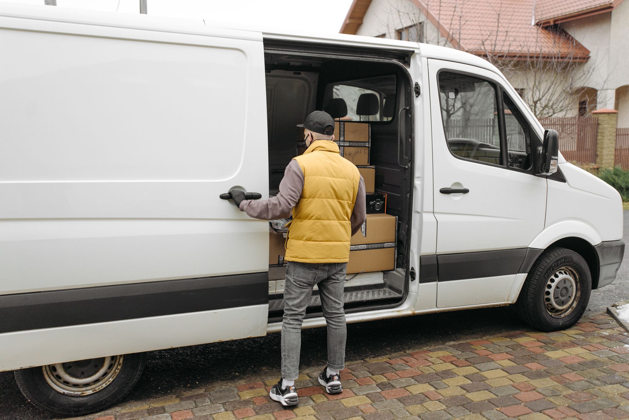 Kurierfahrer belädt seinen Transporter mit Paketen vor der nächsten Tour